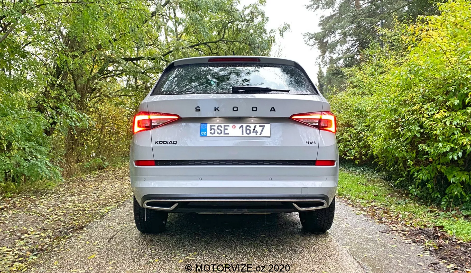 Vista de ângulo traseiro de um Škoda Kodiaq prateado de 2017. Destaca-se o logótipo Škoda no centro do porta-malas, o nome do modelo 'KODIAQ' e a indicação da versão '4x4', com placa de licença tcheca entre luzes traseiras LED modernas, para-choque de dois tons, refletores e possivelmente sensores de estacionamento.