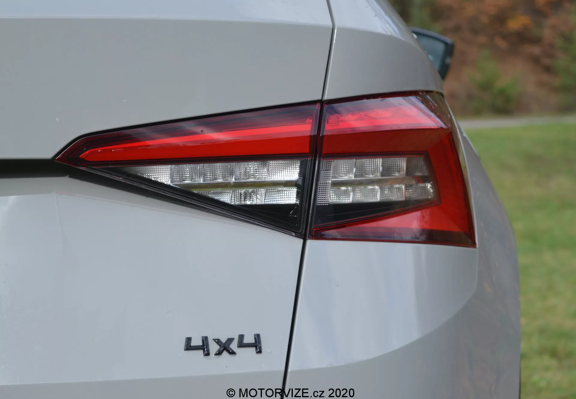 Vista aproximada da luz traseira esquerda do Škoda Kodiaq 2017, mostrando design angular de LED, pintura brilhante de cor clara e emblema 4X4, destacando os detalhes do veículo moderno e a característica de tração nas quatro rodas.