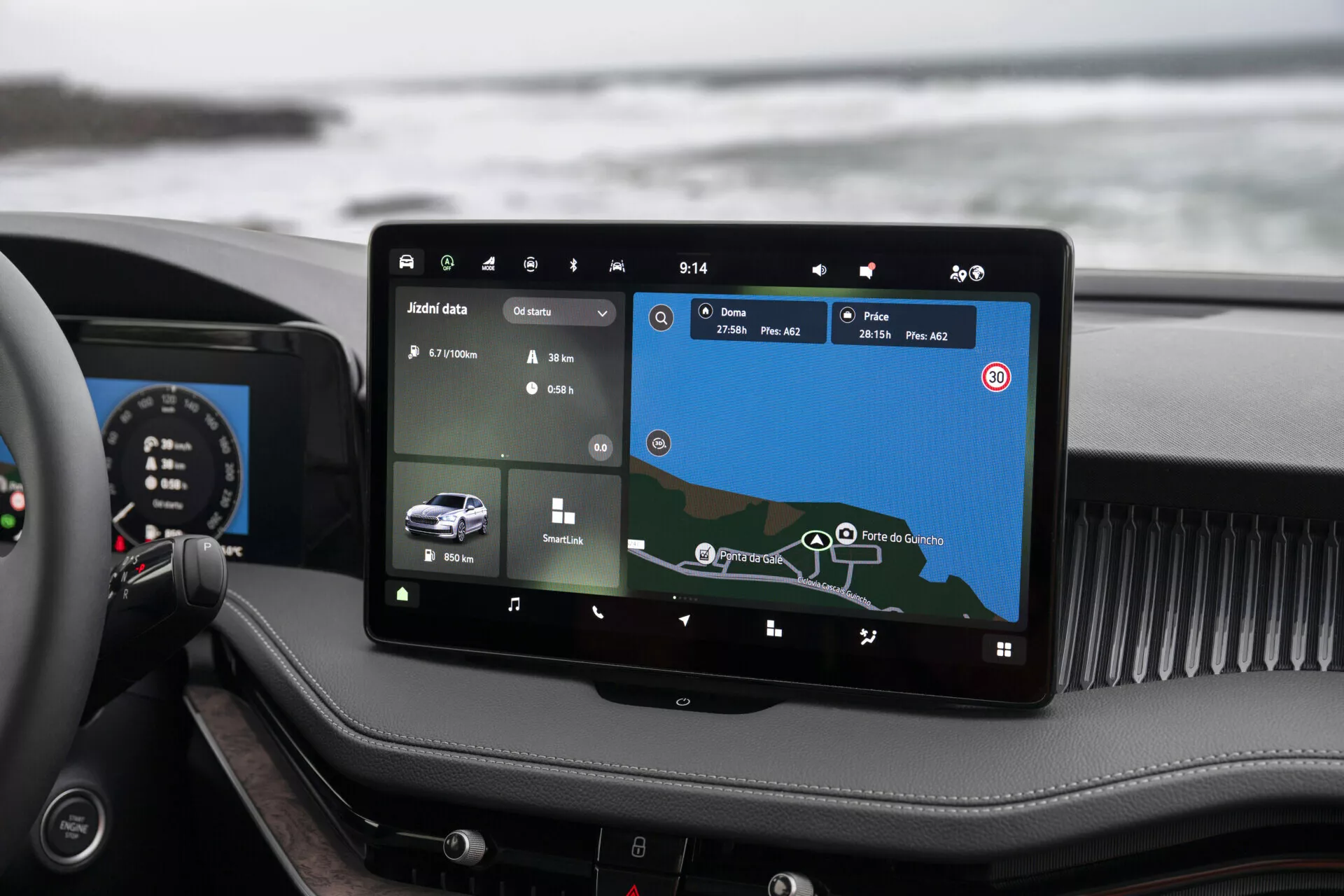 Vista interna do Skoda Superb Limousine 2024 destacando o avançado sistema de infoentretenimento montado de forma proeminente no centro do painel de instrumentos. A tela sensível ao toque, com aproximadamente 10 a 12 polegadas, exibe um mapa de navegação e dados do veículo. Ícones para várias funcionalidades, como controle de clima e configurações do veículo, são visíveis, indicando um sistema de infoentretenimento abrangente com potencial integração de Bluetooth, Wi-Fi e smartphone. O design luxuoso geral é evidente por meio de materiais de alta qualidade e um painel híbrido que combina elementos analógicos e digitais.