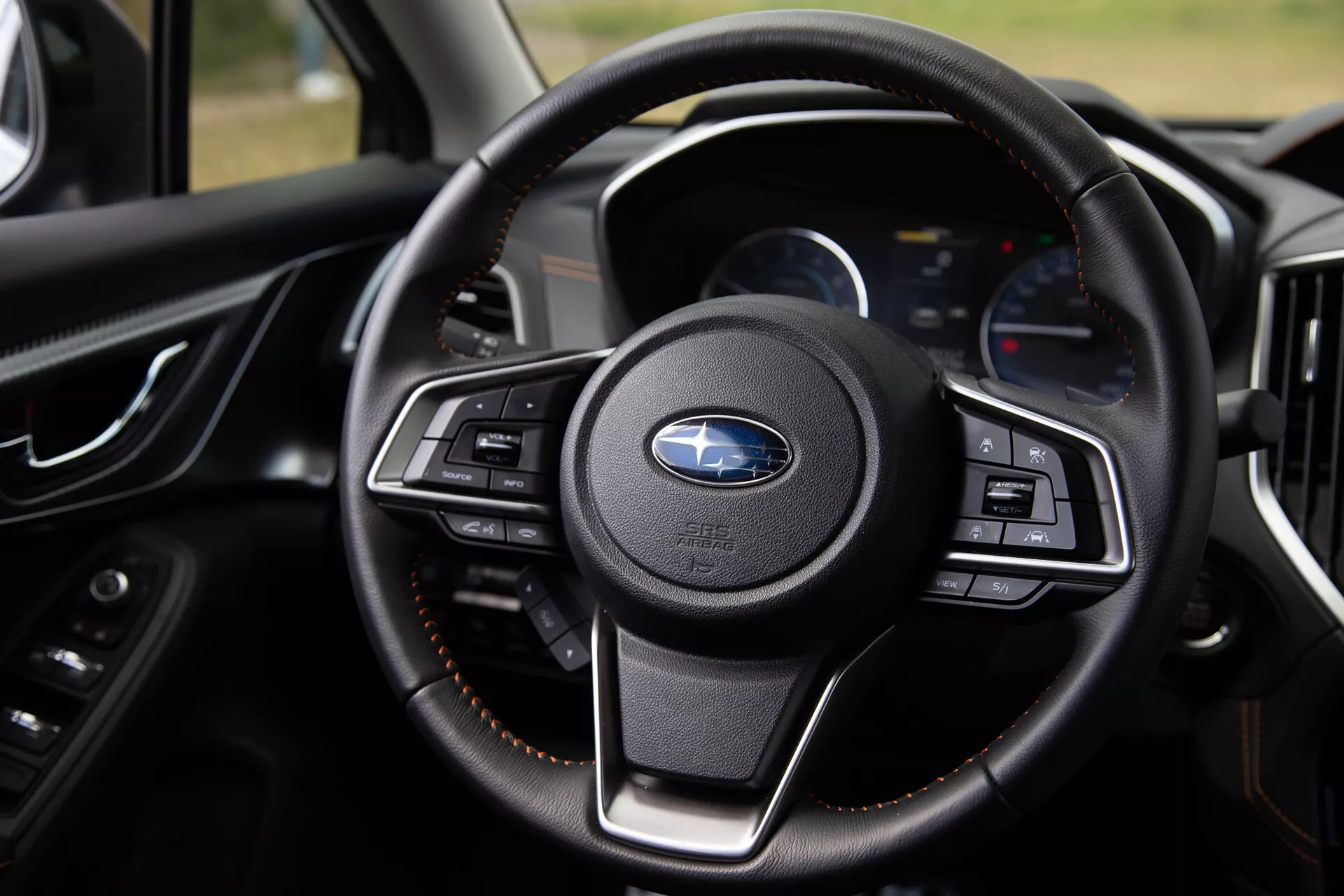 Vista detalhada do volante do Subaru XV 2021 destacando seus botões multifuncionais, revestimento de couro luxuoso e painel moderno com displays digitais