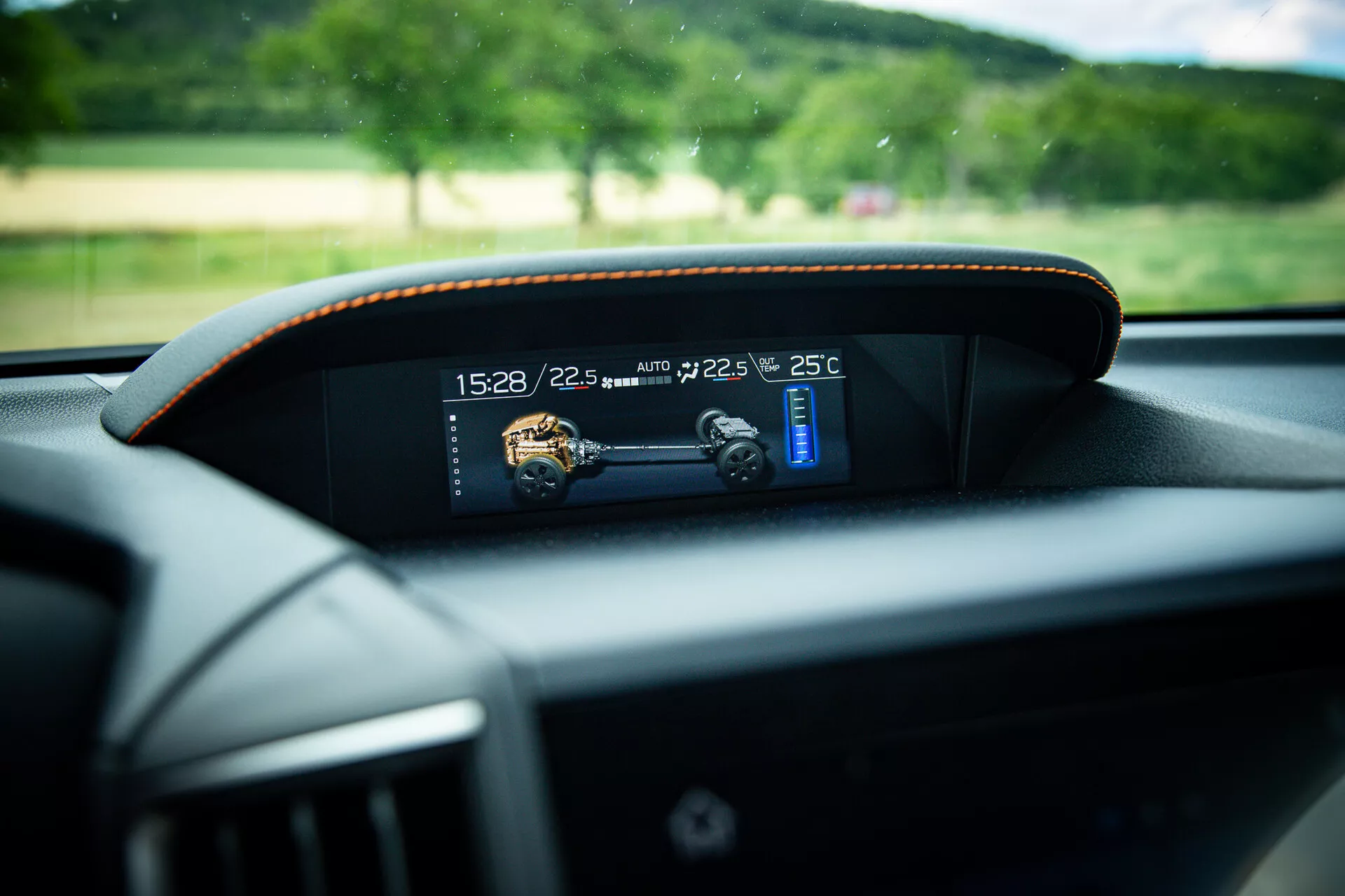 Vista de perto do painel digital moderno em um Subaru XV 2021, mostrando indicadores de tempo, temperatura e velocidade com costura de contraste sutil em volta da moldura, tirada da perspectiva do assento do motorista