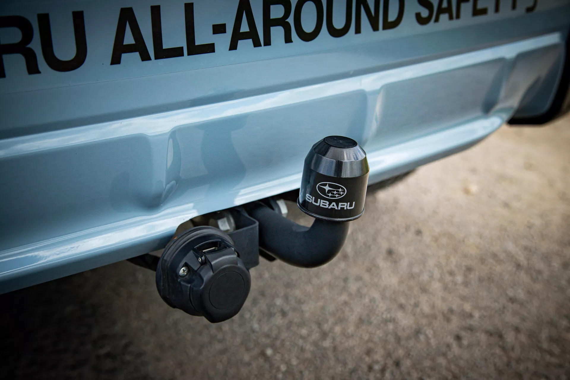 Vista detalhada da área do engate traseiro do Subaru XV 2021 com o logotipo da SUBARU em relevo na cobertura do engate, destacando características de segurança e aventura