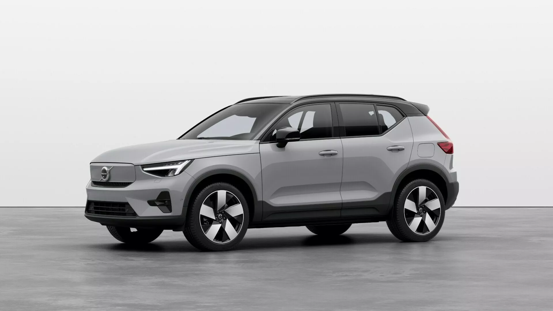 SUV elétrico Volvo EX40 1ª geração 2024 em cenário de estúdio, exibindo perfis frontal e lateral com faróis LED, grade fechada, rodas de liga leve multifaladas e sensores de alta tecnologia