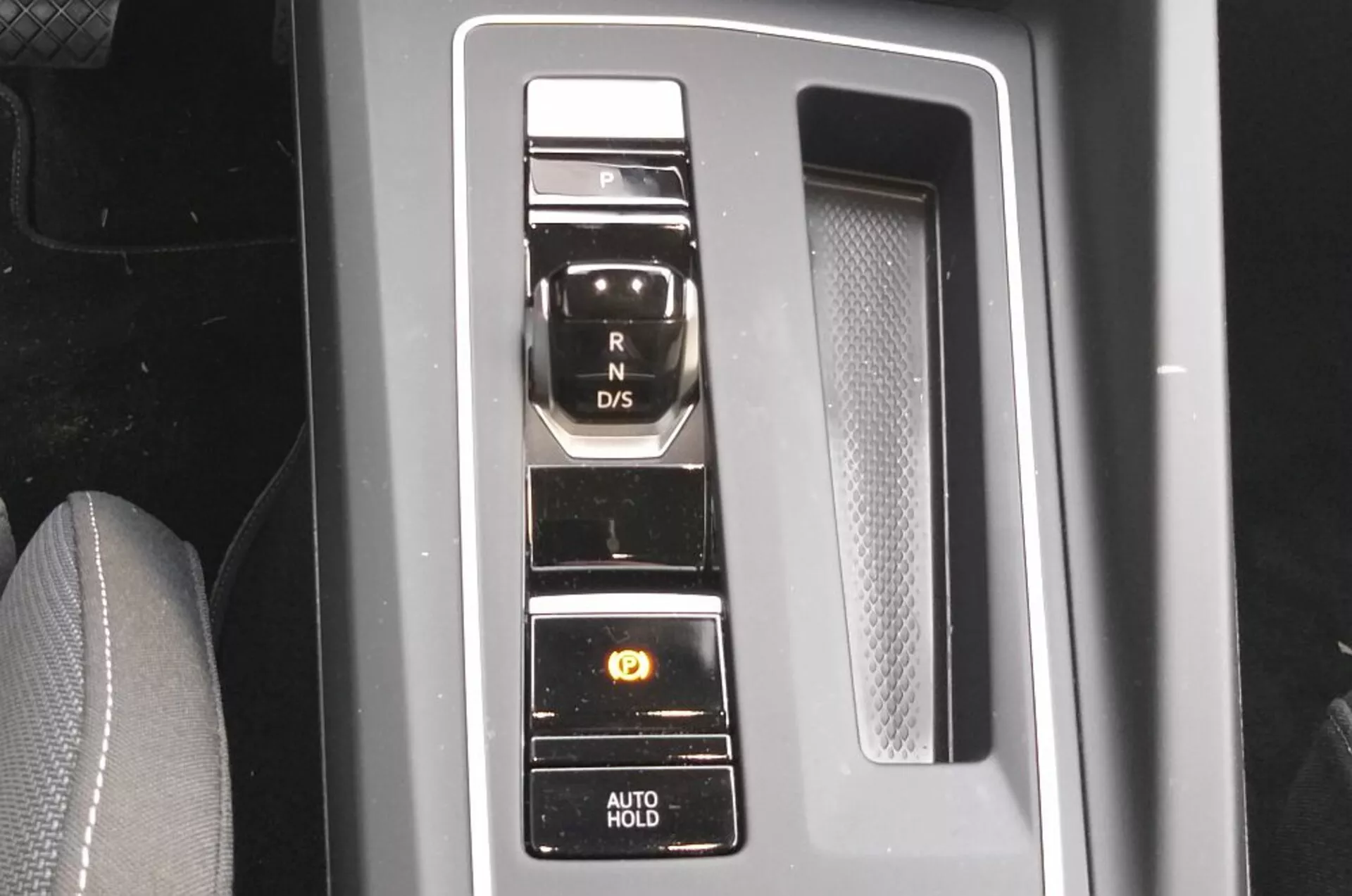 Vista detalhada do seletor de marchas eletrônico do VW Golf GTD 2017 com botões dispostos verticalmente em um painel preto de piano com acabamentos em cromo, exibindo a tecnologia moderna do sistema de transmissão e recursos de conveniência como o freio de estacionamento e função AUTO HOLD